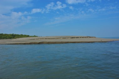 Bakkhali Nehri 'nin Cox' s Bazar yakınlarında Bengal Körfezi 'yle buluştuğu sakin sahil manzarası, kumlu kıyı şeridi, sakin su ve açık kıyı ufkunun yer aldığı Bangladeş' te gün ışığı altında