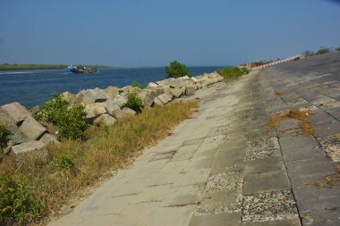 Bangladeş kıyısındaki Maheshkhali Kanalı boyunca kaya seti gelgit sularını, kıyı şeridini ve sakin bir tropikal estuarin ortamında kıyı mühendisliğini gösteriyor..