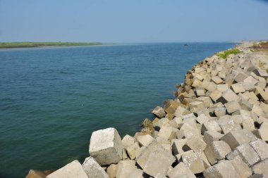 Bangladeş kıyısındaki Maheshkhali Kanalı boyunca kaya seti gelgit sularını, kıyı şeridini ve sakin bir tropikal estuarin ortamında kıyı mühendisliğini gösteriyor..