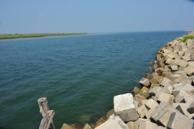 Bangladeş kıyısındaki Maheshkhali Kanalı boyunca kaya seti gelgit sularını, kıyı şeridini ve sakin bir tropikal estuarin ortamında kıyı mühendisliğini gösteriyor..