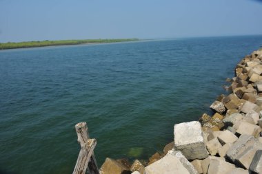 Bangladeş kıyısındaki Maheshkhali Kanalı boyunca kaya seti gelgit sularını, kıyı şeridini ve sakin bir tropikal estuarin ortamında kıyı mühendisliğini gösteriyor..