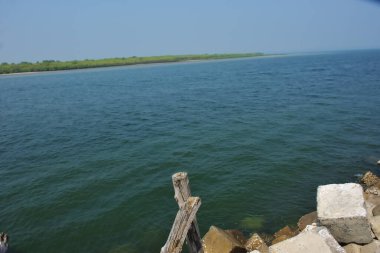 Bangladeş kıyısındaki Maheshkhali Kanalı boyunca kaya seti gelgit sularını, kıyı şeridini ve sakin bir tropikal estuarin ortamında kıyı mühendisliğini gösteriyor..