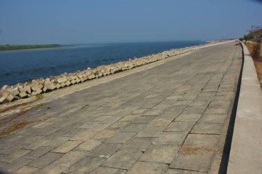 Cox 's Bazar, Bangladeş' teki Maheshkhali Kanalı boyunca yer alan beton blok seti ve kıyı şeridi erozyon kontrolü ve deniz altyapısı için ağır görev taşları ve çimento yapıları yer alıyor..