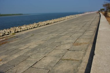 Cox 's Bazar, Bangladeş' teki Maheshkhali Kanalı boyunca yer alan beton blok seti ve kıyı şeridi erozyon kontrolü ve deniz altyapısı için ağır görev taşları ve çimento yapıları yer alıyor..