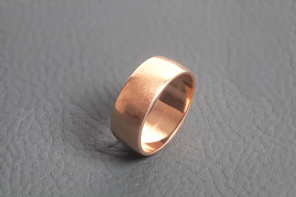 Bague de mariage dorée sur fond gris — Photo