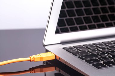 turuncu kablolu laptop.