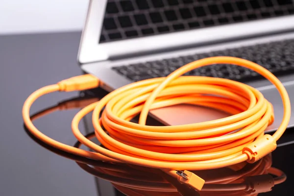 laptop with orange rolled cable.