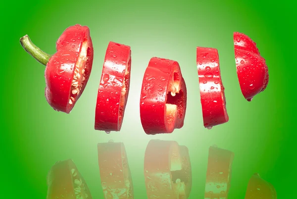 Plasterki Czerwonej Papryki Latające Zielonym Tle — Zdjęcie stockowe