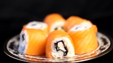 Suşi ruloları tabakta dönüyor. 4K