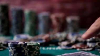 Royal Floş kartlarını elinde tutan oyuncu. Kumarhanede poker masasında çipler, kartlar ve zarlar.