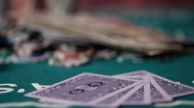 Royal Floş kartlarını elinde tutan oyuncu. Kumarhanede poker masasında çipler, kartlar ve zarlar.