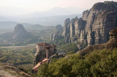 Meteora, Yunanistan 15 Ekim 2008: Yunanistan 'ın orta kesimindeki kayalıklar ve vadilerle çevrili, Meteora' daki devasa kaya oluşumlarının üzerine inşa edilmiş antik bir manastırın görüntüsü.