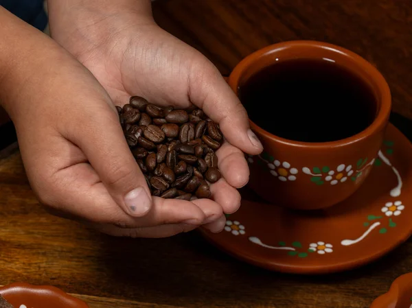 Kahve çekirdekleri ve baharatlar kil bardağa dökülüyor.
