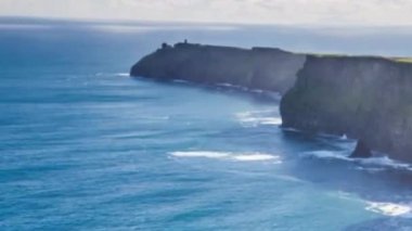 Mavi Atlantik kıyısında dalgaları olan engebeli deniz kayalıkları