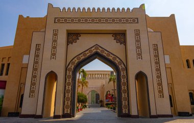 Katar 'ın Doha kentindeki geleneksel Katara köyünde kemer girişi ve palmiye ağacı