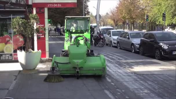 市政当局的工作人员使用绿色工作机器对街道进行清洗和消毒 配备车辆和背景人员 — 图库视频影像