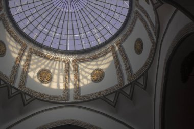 Sarı desenlerle dekore edilmiş bir caminin kubbesi, gündüz vakti yerden çekiliyor.