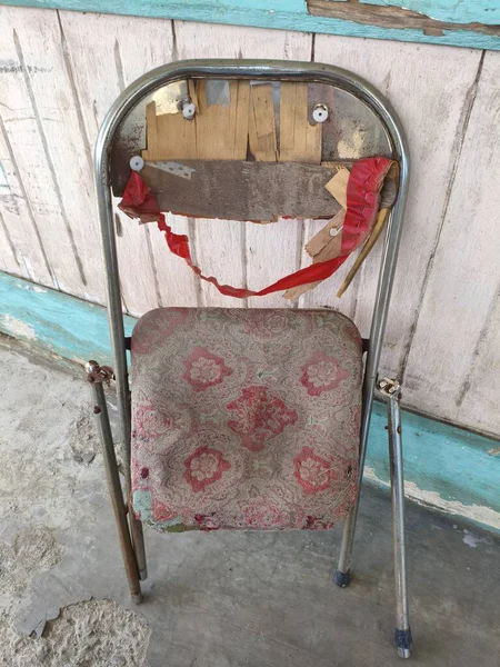 Yerdeki paslı sandalye.