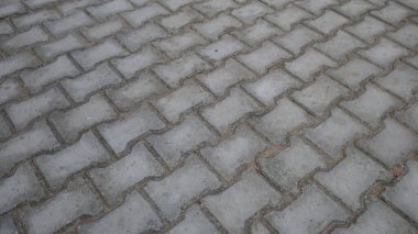 Somut ürünler, inşaat endüstrisi, asfalt zemin. Gri ve beyaz beton bloklarla kenetlenmiş kaldırımlar.