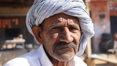 Mayıs 20- Mahroly, Jaipur, Hindistan. Hüzünlü ve işsizlik sorunu çeken yaşlı Hintli adamın buruşuk yüzüne odaklanın. Çoban kuşu 19 salgını sırasında..