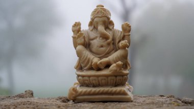 Beyaz plastik malzemeden yapılmış Ganesha heykeli ve Hint Evi 'nin önünde izole edilmiş. Sisli bir sabah ve tanrı heykeli.