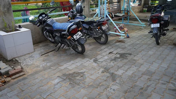 10 Ocak 2021 - Reengus, Jaipur, Hindistan. Evdeki betonarme blok zemininde üç motosiklet ya da bisikletin görüntüsü.