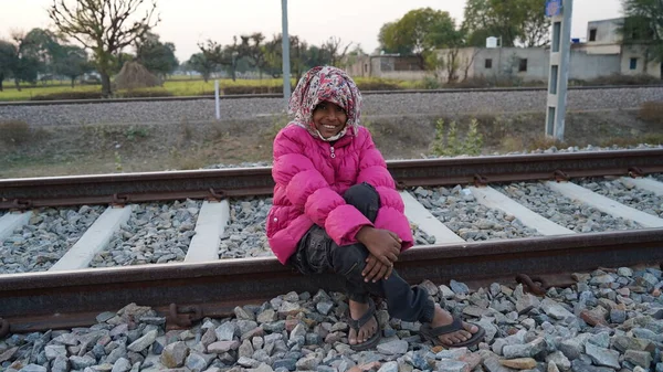 笑着坐在铁轨上的印度女孩 小女孩的前排拍摄在货运铁路运输线上 — 图库照片