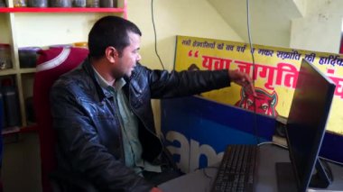 Hintli ofis çalışanı, masaüstü ve satış ve alım hesaplarını denetlemekle meşgul. Hesap yönetimi yazılım kavramı.