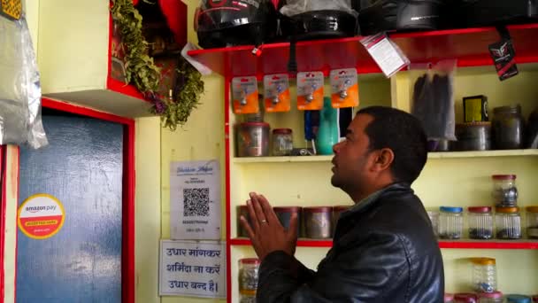 젊은 남자가 예비 부품 가게를 열고 신께 경배를 드린다. 인도 문화와 사업 개념. — 비디오
