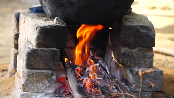 Traditional stove footage with illuminating fire. Natural fire for cooking with pots and pans on the stove. Natural wood sticks in the stove. — Stock Video