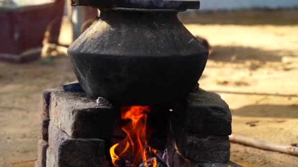 Традиционный способ приготовления пищи на открытом огне на старой кухне в деревенском отеле, Раджастхан Индия. Кастрюли и сковородки на плите над естественным камином для приготовления пищи. Сельская кухня с использованием биотоплива для приготовления пищи — стоковое видео