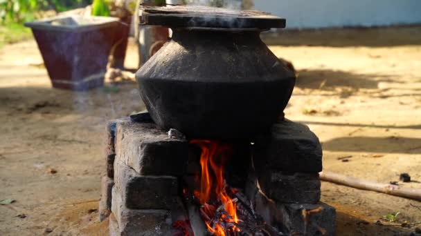 Tradiční způsob vaření jídla na otevřeném ohni ve staré indické kuchyni ve vesnickém domě na venkovském sporáku. Pohled na cihlová kamna s načervenalým osvětlujícím ohněm. — Stock video