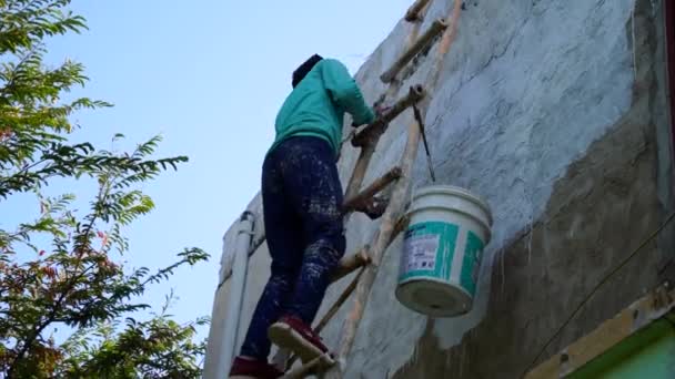 Um jovem pintor indiano rolando a cor nas paredes. Pintor fazendo cor e embelezando as paredes da casa. — Vídeo de Stock