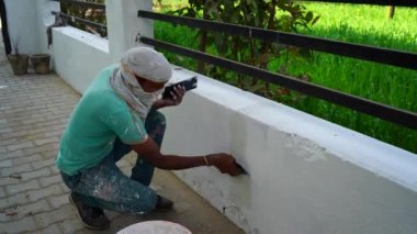 Duvarda macun sıvası var. Alçıdan duvar ya da kaplama duvar. İç kısımlarda çalışan Hintli adam..