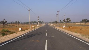 Hindistan 'ın kırsal yolları ufka açılıyor. Trafik ve ulaşım olmadan asfalt yol.