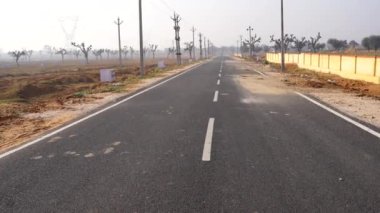 Asfalt yolu ve güzel kırsal ufuk çizgisi sabah vakti. 4k 'lık boş asfalt yolu görüntüsü.