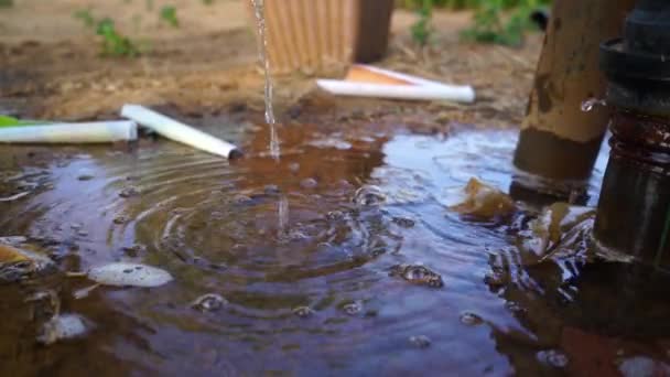 Le gocce d'acqua fuoriescono dal tubo di plastica. Un sacco di acqua raccolta vicino alla curva dell'acqua. Perdita tubo di collegamento acqua spruzzatura. — Video Stock