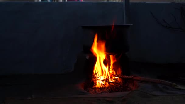 Červený plamen ohně v tradičních jílových kamnech na venkově. Dřevěné tyčinky hořící v krbových kamnech s hliníkovou pánví. — Stock video