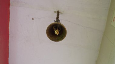 Çatı katına bağlı tapınak yüzüğünün asılması. İbadete adanmış çan bir tapınağa yakın..
