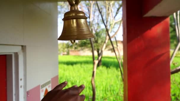 Campana de bronce dorado sonando a mano humana. Imágenes de primer plano de la campana de latón colgando en el templo hindú religioso. — Vídeo de stock
