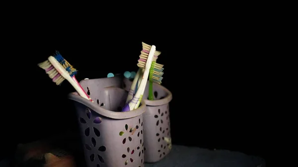 Night shot of plastic toothbrush holder with brushes. Concept of cleaning and care of the teeth in a scandinavian bathroom. Oral hygiene. concept of dental care.