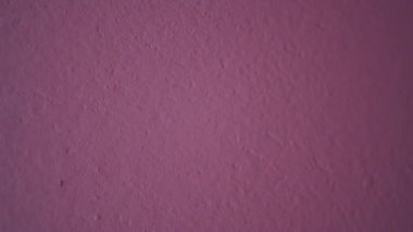 Duvarda pembe bir renk var. Güzel dekoratif duvar odası. Kapatın. Beton duvarın pembe yüzeyi.