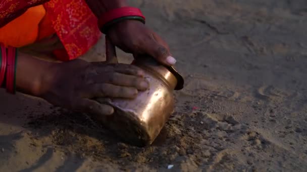 Kvinnan handrengör kökskärlen med jord och vatten. Forntida sätt att sanera redskap. — Stockvideo