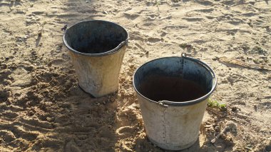 Eski paslı demir kova. Gün ışığında hayvan çiftliğinde boş bir kova tutuyor. Hayvanlara su için kova.