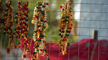 Rengarenk güzel çiçekler sarkmış. Demir çitlerde çiçek çelenkleri asılı. Çekici bir tasarım ile kapılar asılı..