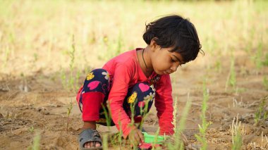 Küçük bebek yerde oynuyor. Tarım arazisinde kamyon oyuncağıyla oynayan küçük bir çocuk. Çocukluk kavramı.