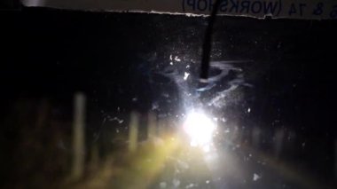 Gece yoldan geçen araba. Gece yolunun arka planında giden araba ve geçen bisikletlerin parıltısı. Kapatın. 4K