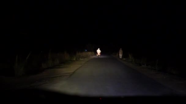 4K. Homme Conduite Voiture à travers les rues de la ville de nuit. Éblouissement à la fenêtre de la voiture. Voiture dépassant les véhicules. — Video
