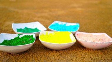 Toprakta bulunan süslü renkli Gulal ve Abhir kâselerine odaklanın. Geleneksel renk kutlaması yakın plan.