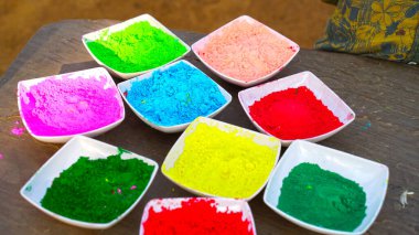 Rangoli renkleri çekici renkli bir kapta duruyor. Holi festivalleri farklı renk gemileriyle kutlanır. Farklı renklerde süslü bir kase..